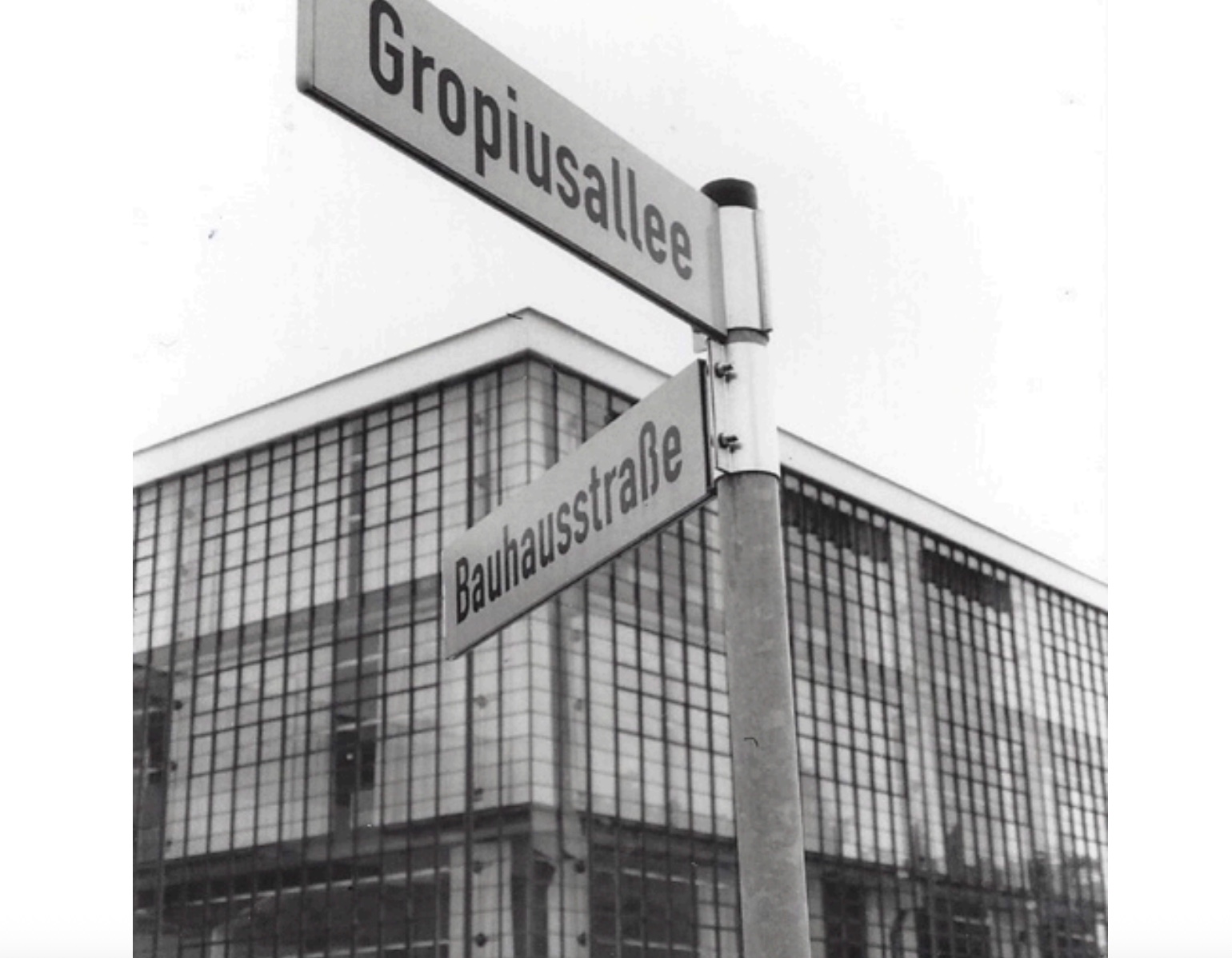 Black and white Bauhaus street sign and glass building.